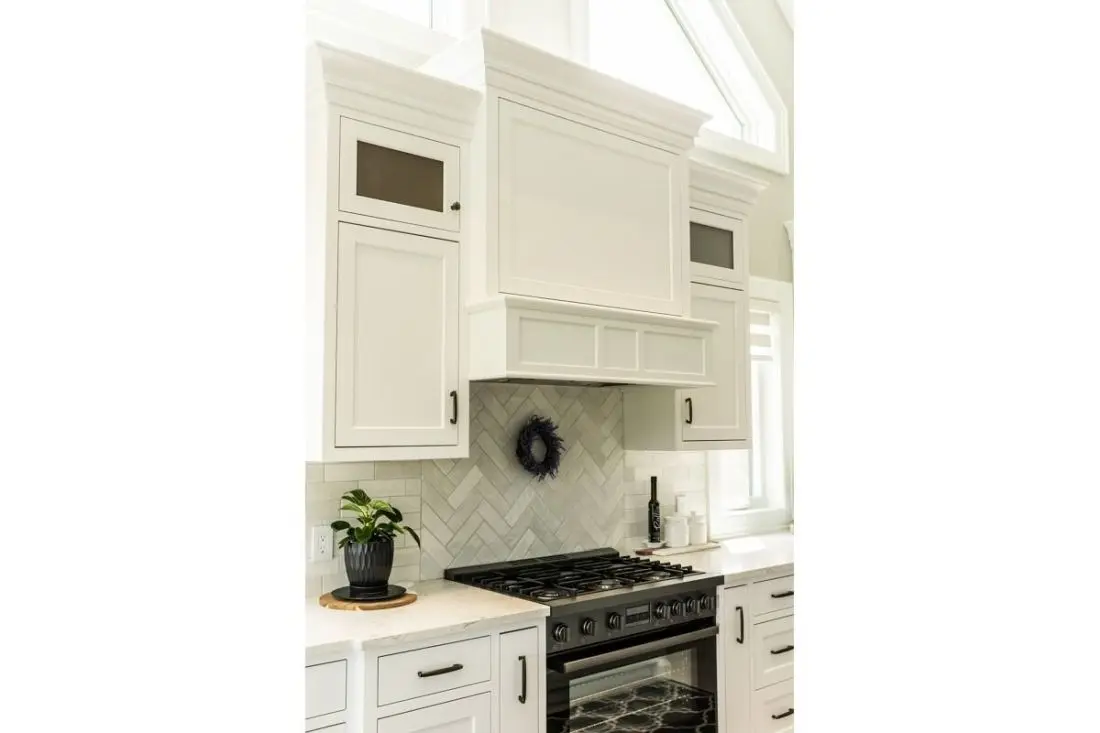 Custom wood kitchen hood with white cabinetry, handcrafted by Homestead Woodworks to match the elegant modern kitchen design